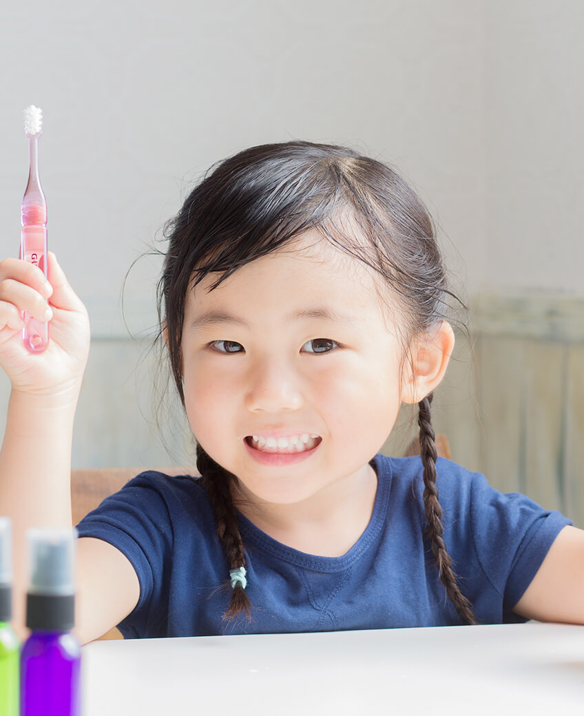 歯ブラシを手に持つ笑顔の女の子